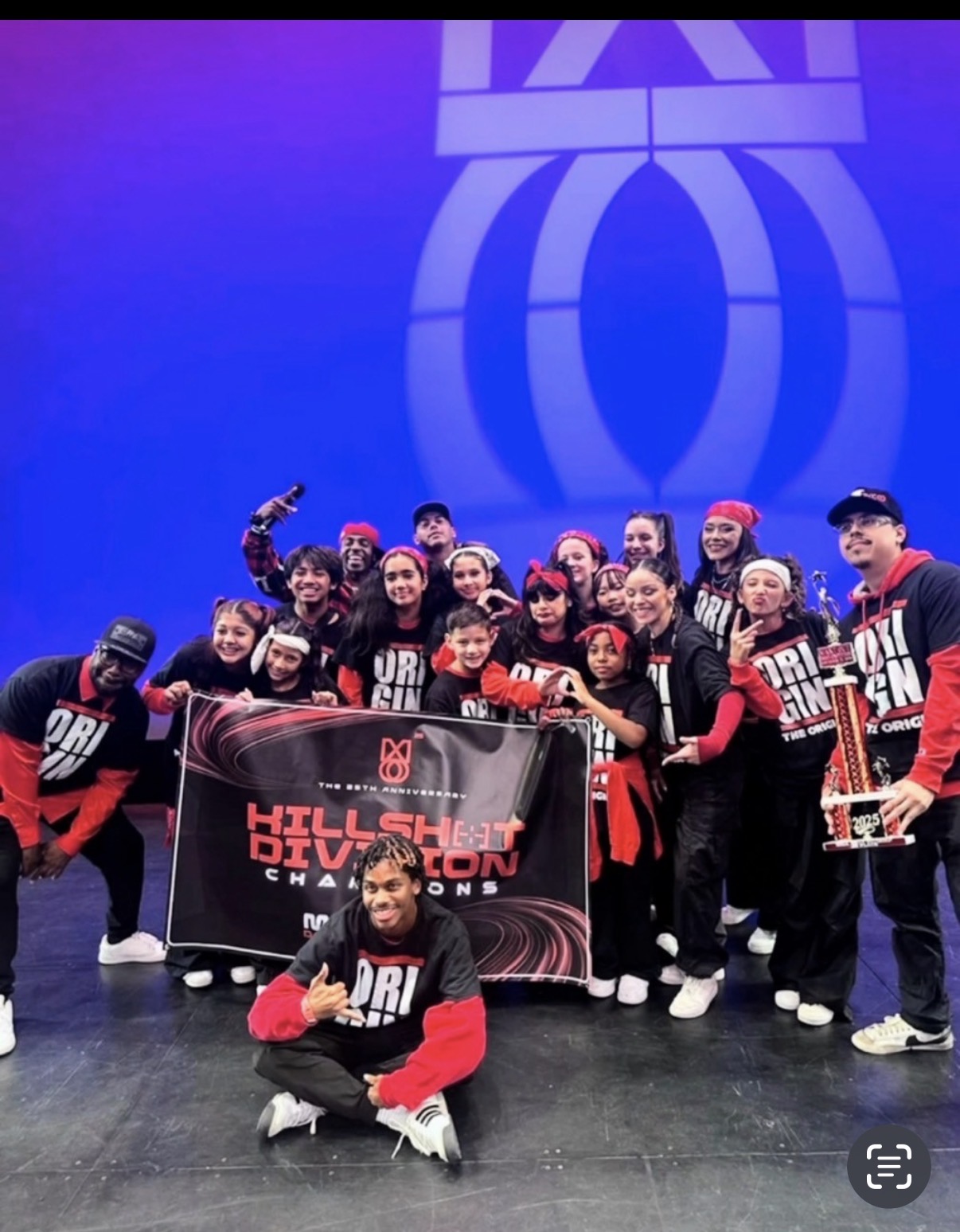 The Origin crew celebrating with a championship banner and trophy