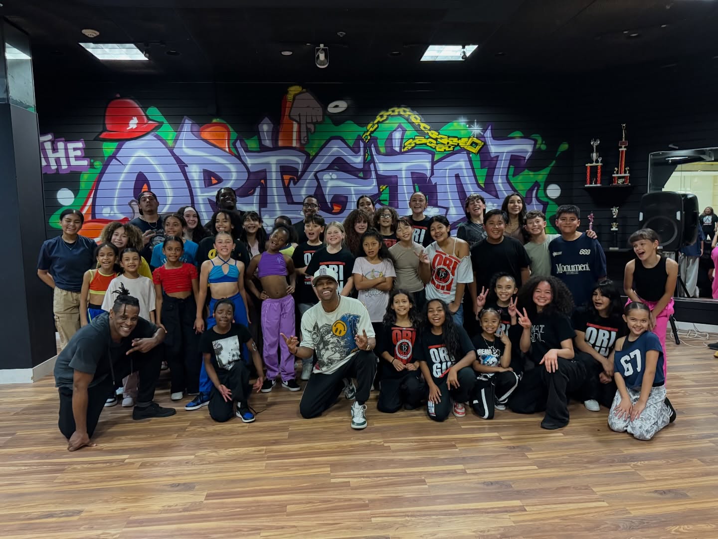 Dancers gathered for Phil Wright’s masterclass at The Origin, in front of the colorful studio mural